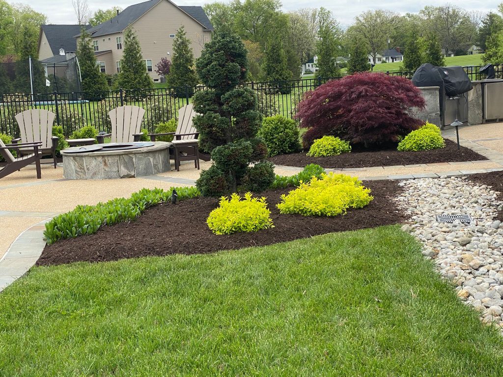 Landscaped garden bed with ornamental shrubs, fresh mulch, and trimmed lawn