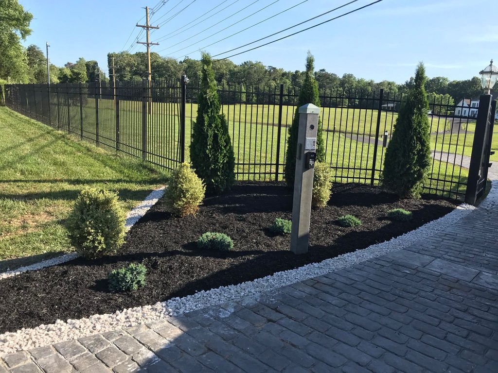 Freshly mulched landscape bed with shrubs and stone edging installed by Andrade's Lawn Services